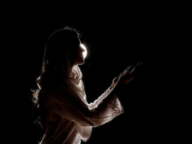 Silhouette of muslim woman praying