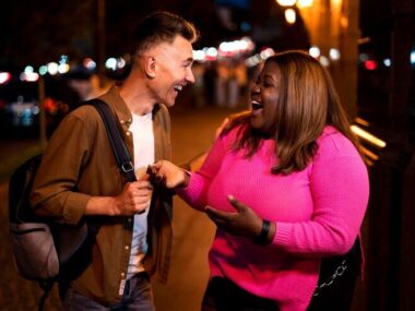 Man and woman talking at night in the city lights