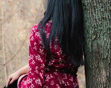 Rear view of woman sitting on field