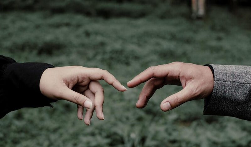 Romantic prewedding with the hands of lovers who meet each other accompanied by a cool natural