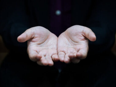 Businesswoman showing empty handed outstretched palm at desk