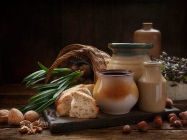 Homemade bread walnuts bulbous plant and vintage ceramic kitchenware on an old wooden table