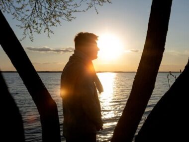 ad and contemplative person near lake