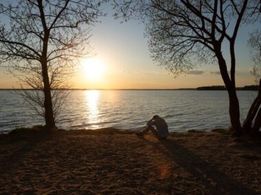 Sad and contemplative person near lake