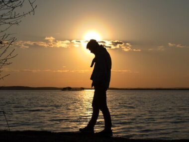 Sad and contemplative person near lake