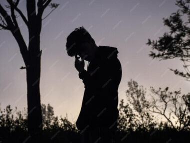 Silhouette man standing on field against sky during sunset