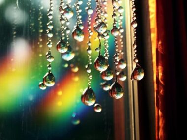 Water drops on a window with a rainbow in the background