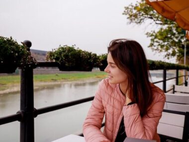 Happy smiling young girl in a cafe. Beautiful girl in trendy autumn colors.