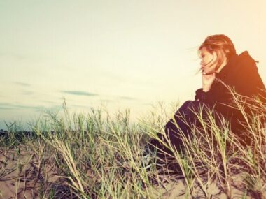 Worried girl sitting on the sand