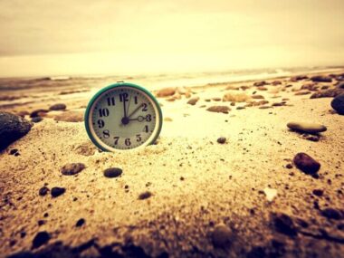 Clock on the beach. Time and business concept.