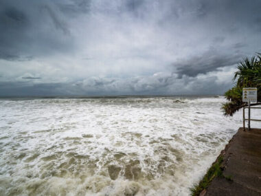 Foamy sore under dark cloudy skies in Alexandra Headland Beach, Queensland Australia