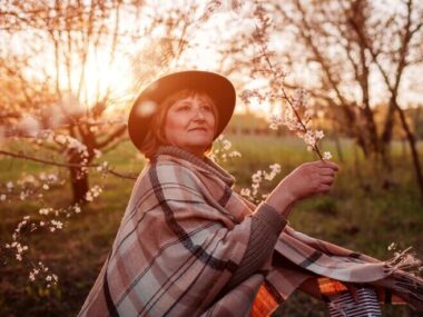 Happy woman relaxing in spring garden. Woman walking and dancing.