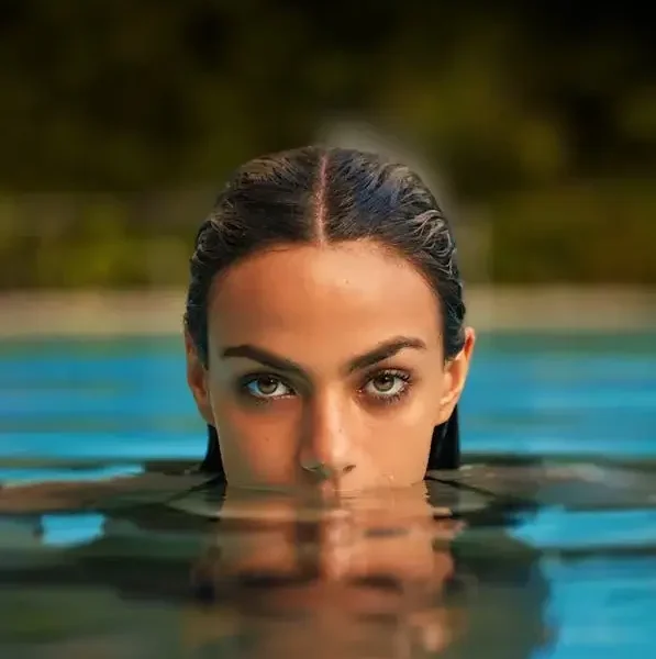 Photo of a Woman Emerging from the Water in a Swimming Pool