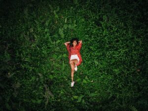 A Woman Lying Down on the Green Grass Field