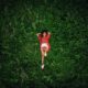 A Woman Lying Down on the Green Grass Field