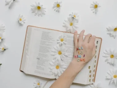 A hand on book with praying message