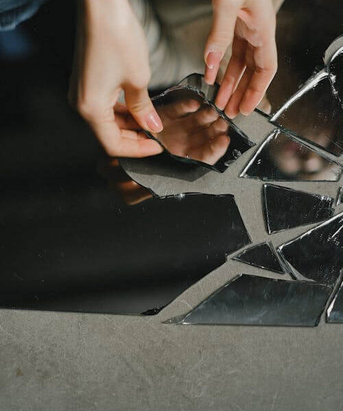 Woman touching broken mirror