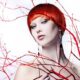 Young beautiful woman with red hair between red branches