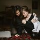 Woman Hugging and Comforting her sad Friend while Sitting on the Floor